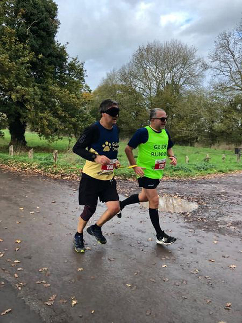 Cliffe Tribe runs with a blindfold guided by John Baker in honour of their friend David Edwards