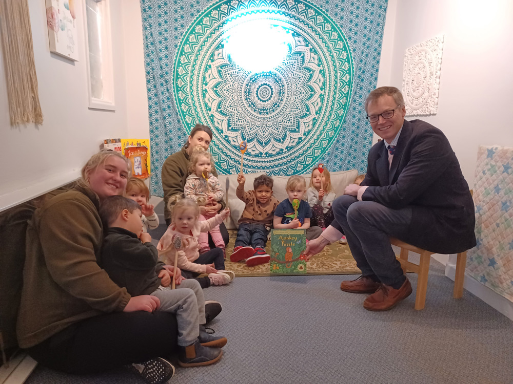 Michael Tomlinson read a children's story to students of Top's Day Nursery
