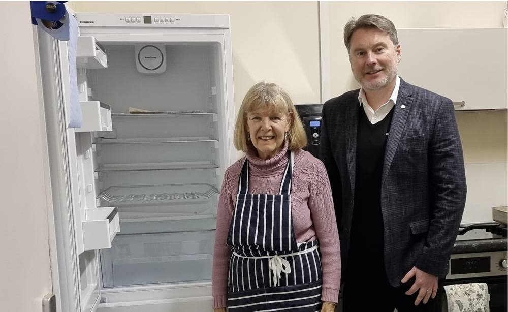 Matt Renaut, managing director of Dacombes in Wimborne, presents the new fridge freezer to Elizabeth Barge, volunteer cook at Wimborne Community Food Supply
