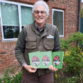 David shows off his book in the gardens he has helped transform at Forest Holme Hospice
