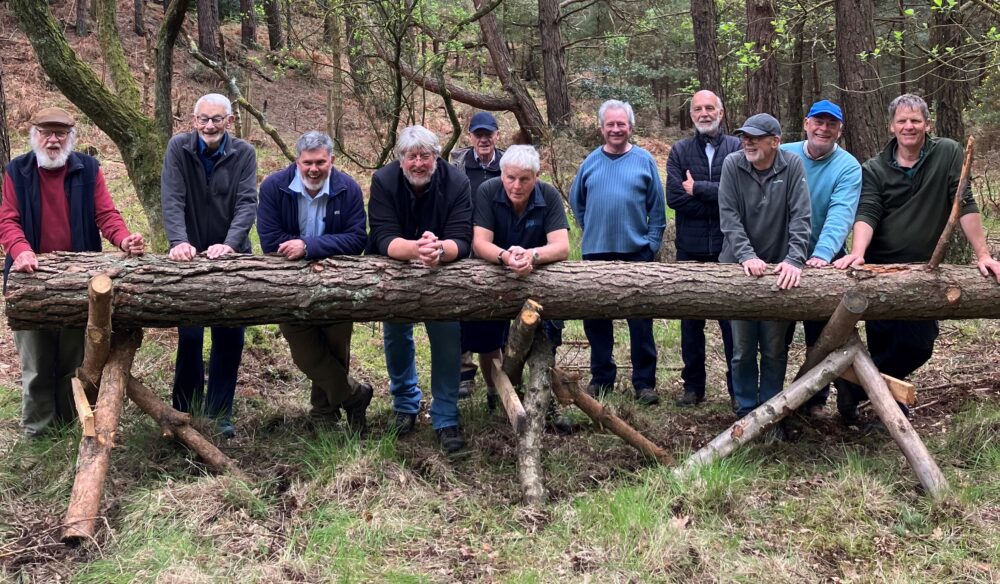 Members of the Men's Shed team with the log used to create a totem pole