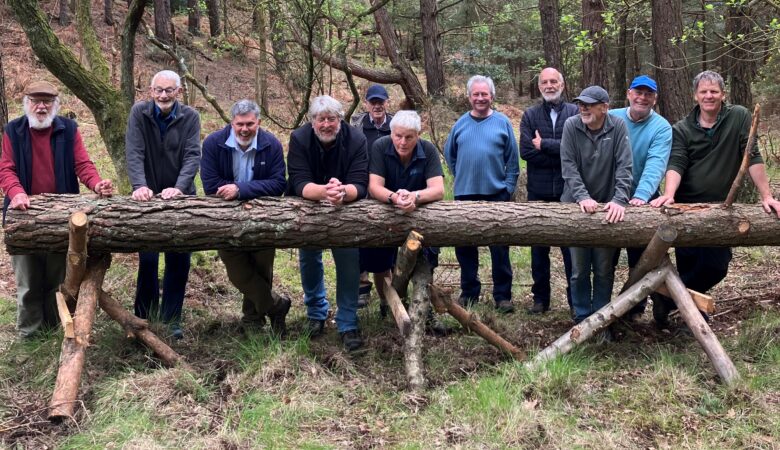 Members of the Men's Shed team with the log used to create a totem pole