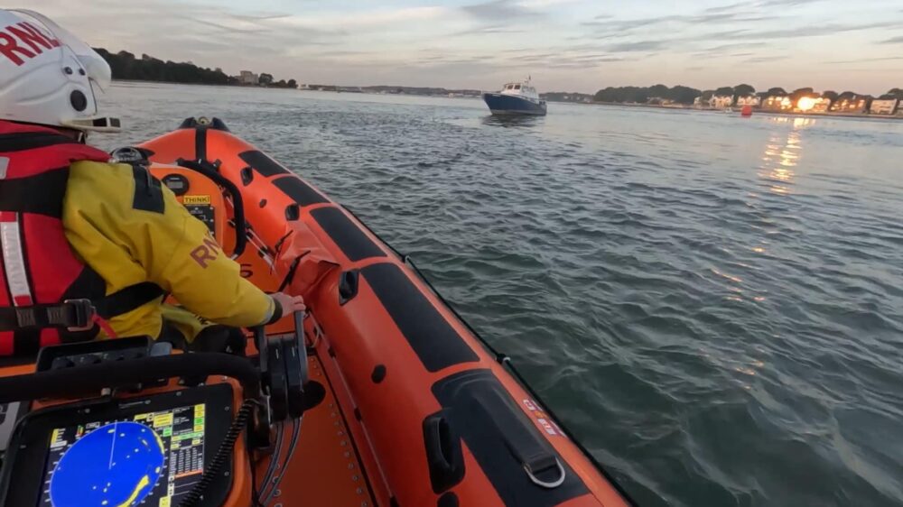 The RNLI lifeboat crew rescuing a flooding boat from Poole Harbour. Photo: RNLI.