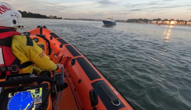 The RNLI lifeboat crew rescuing a flooding boat from Poole Harbour. Photo: RNLI.